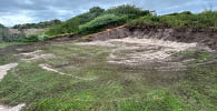 A green field with a dirt mound in the middle. AI generated content