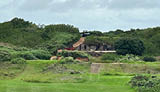 A green golf course with a building in the background. AI generated content
