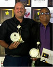 Two men are holding awards at a ceremony. AI generated content