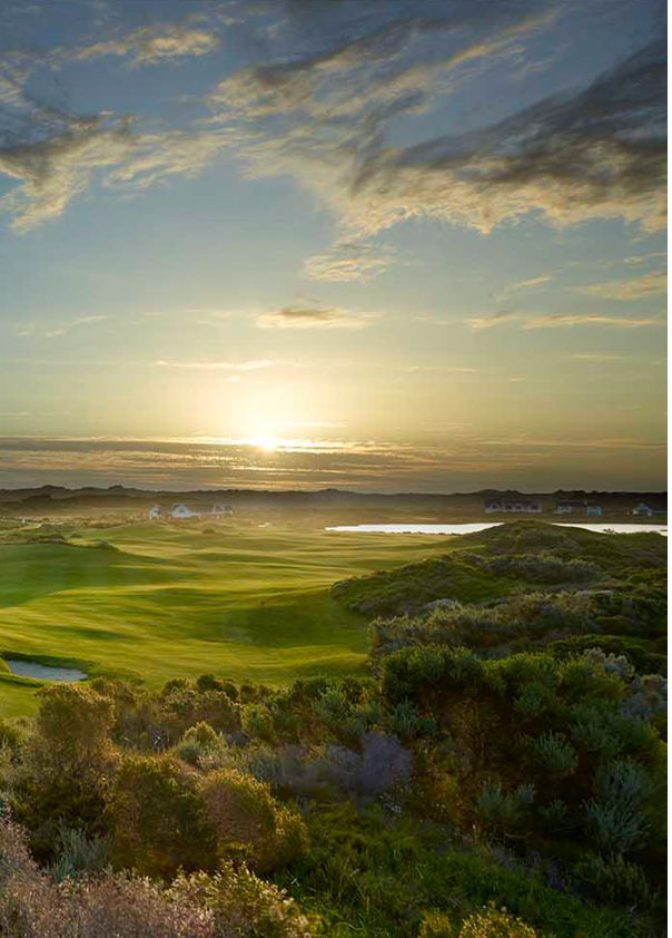 A beautiful sunset over a golf course with a green field and a lake in the background. AI generated content