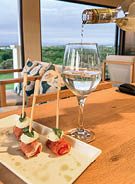 A plate of food is on a table with a wine glass and a bottle of wine. AI generated content