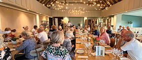 A group of people are sitting around a large dining table in a restaurant. AI generated content