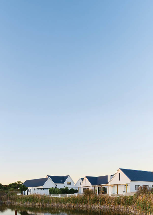 A house is reflected in a pond, with a blue sky above. AI generated content