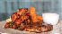 A plate of food on a table, including steak, fries, and a dipping sauce. AI generated content